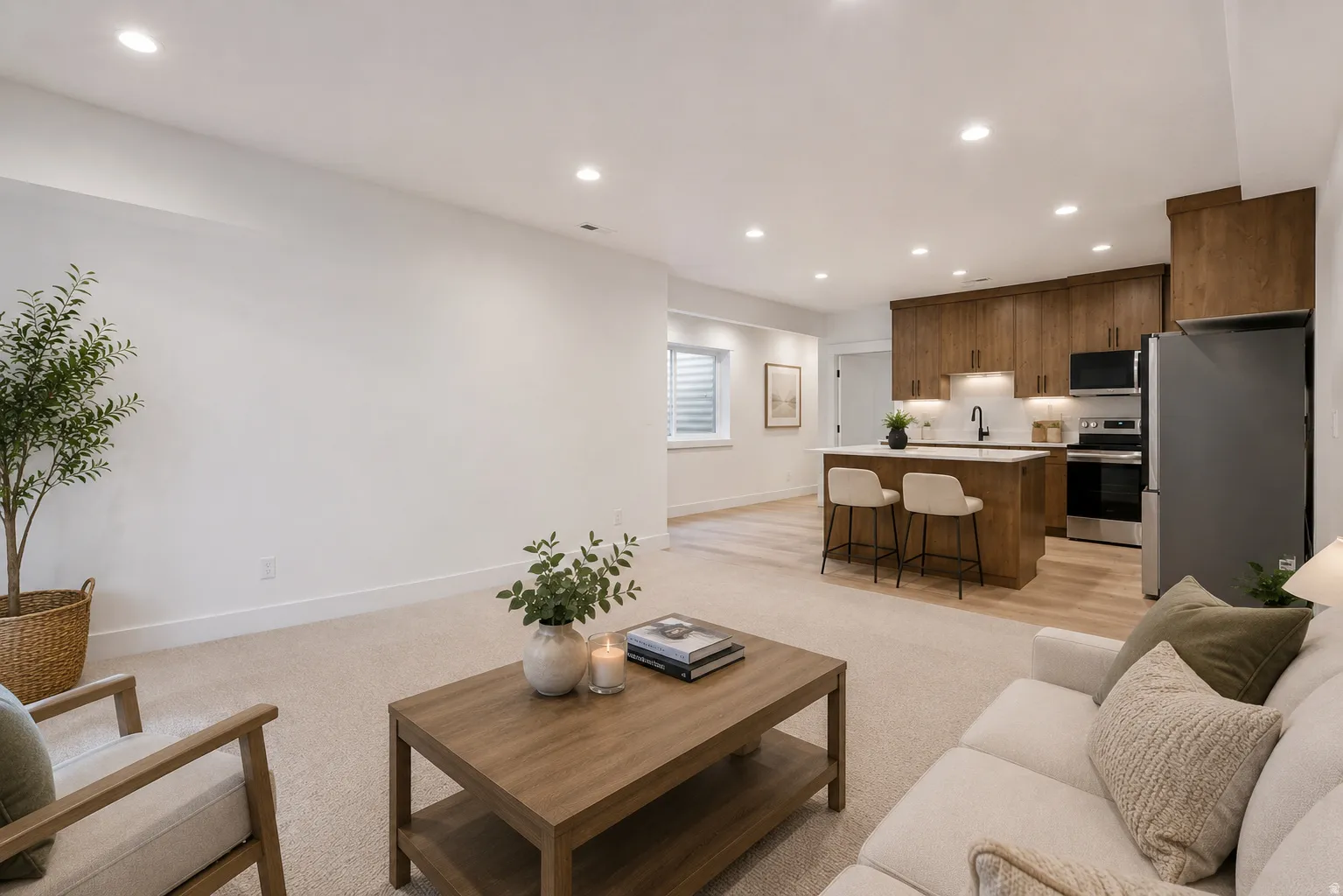 Open-concept living space featuring recessed lighting and a kitchen with wood-finish cabinetry, a central island, and stainless steel appliances