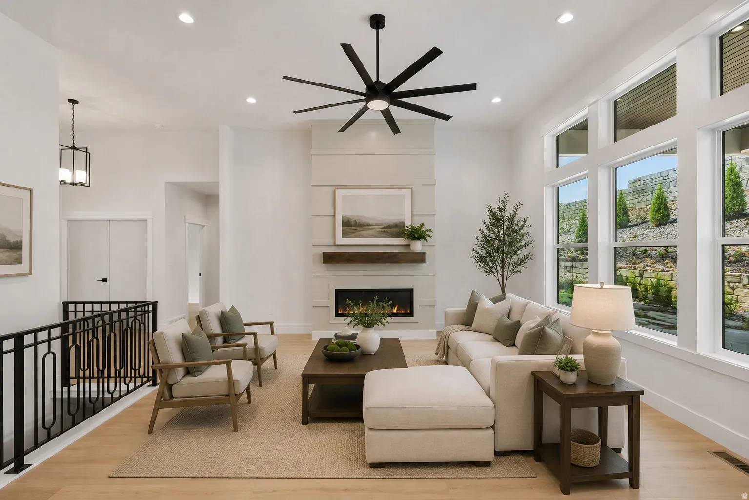 Living space featuring a natural gas fireplace with a wood mantle, shiplap accent wall, and a multi-blade ceiling fan