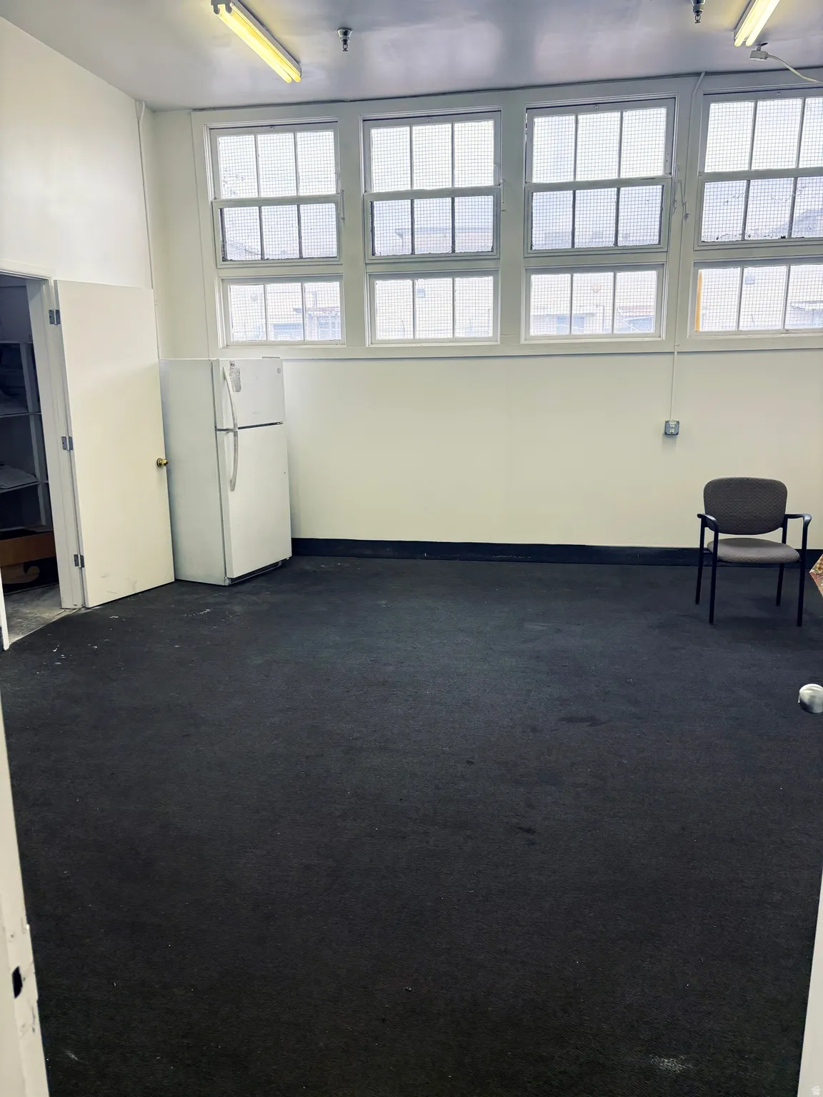 Spare room with dark colored carpet and baseboards