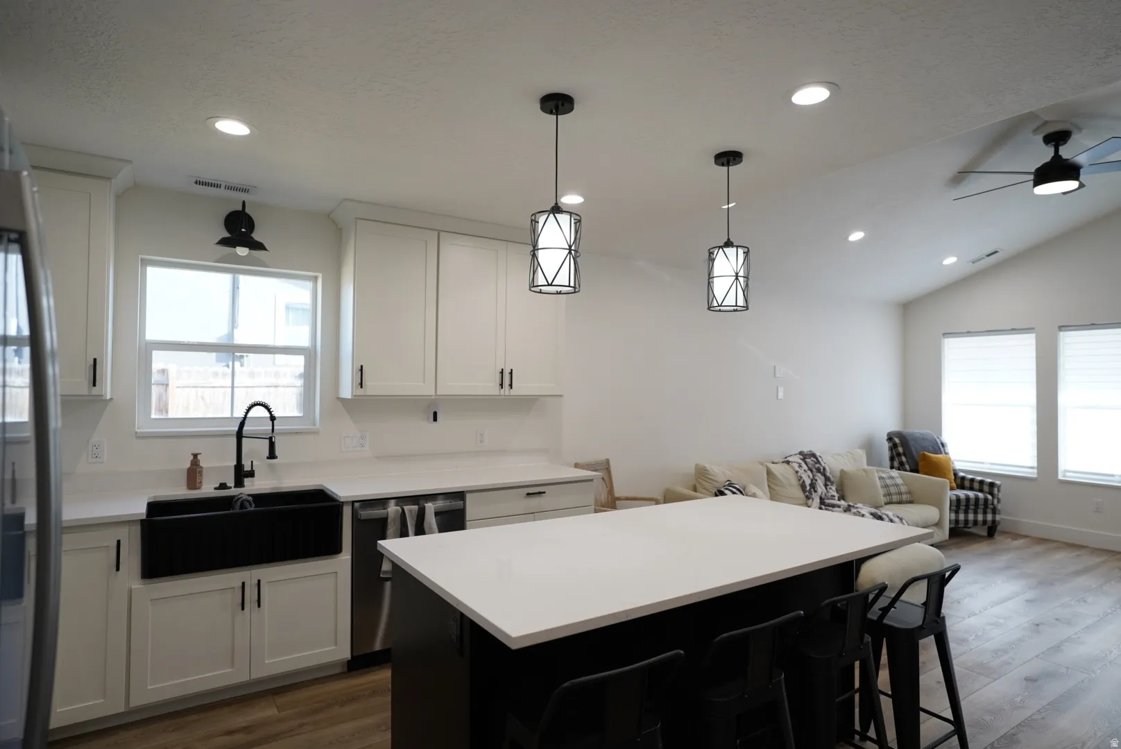 Kitchen featuring white cabinets, dark cabinetry, appliances with stainless steel finishes, dark wood finished floors, and recessed lighting
