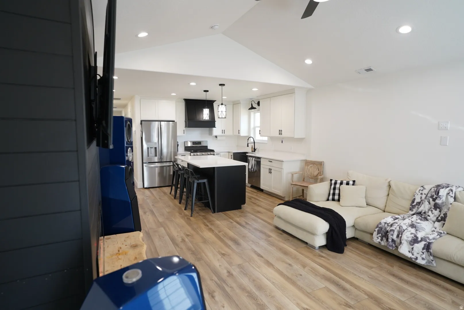 Living room featuring light wood-type flooring, lofted ceiling, recessed lighting, and a ceiling fan