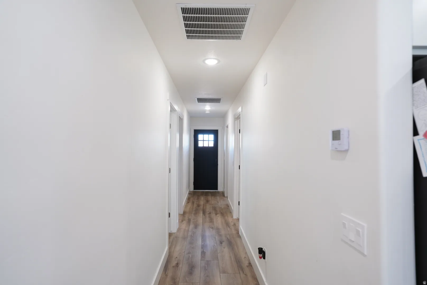 Hallway featuring light wood finished floors and baseboards