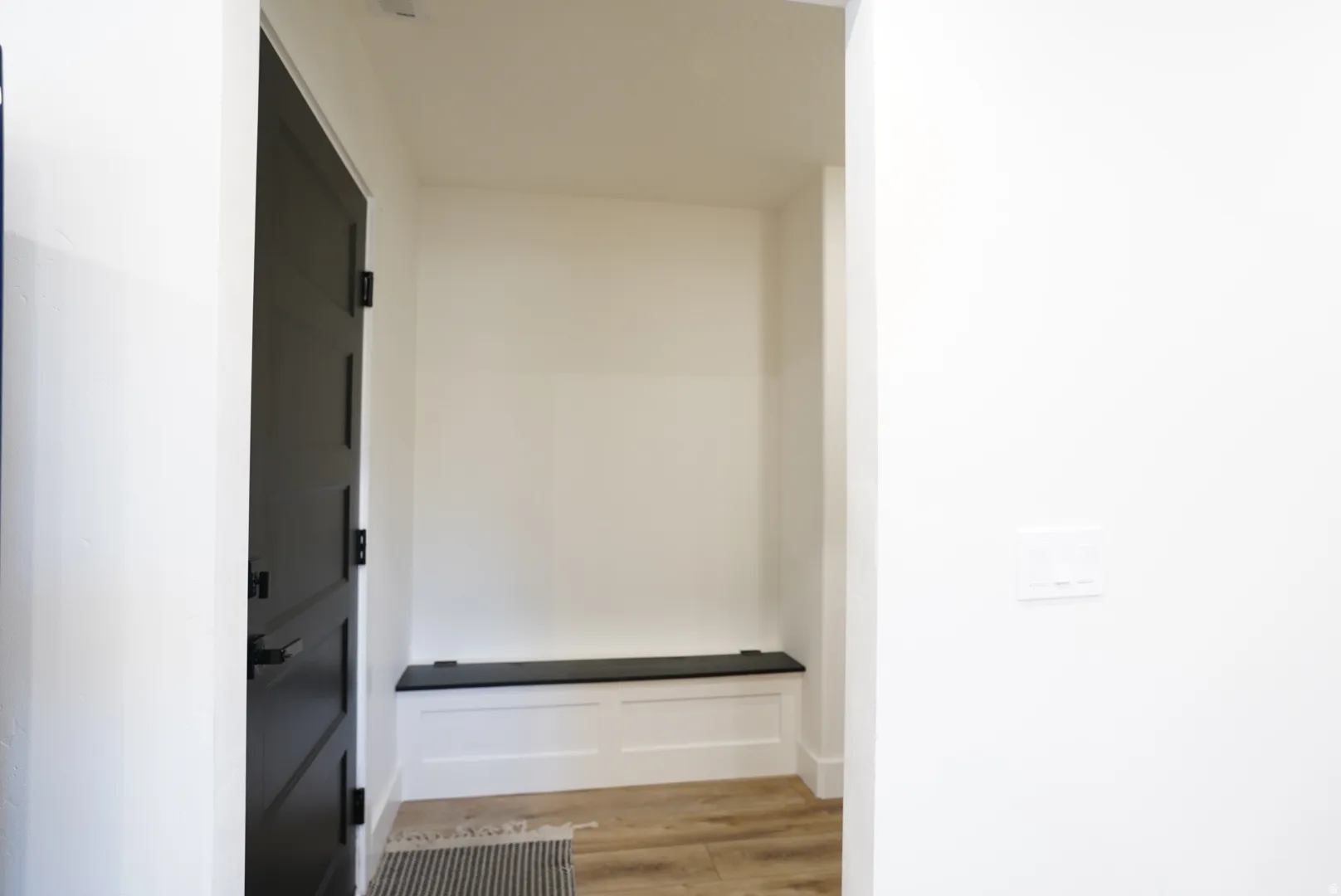 Corridor with light wood-type flooring and baseboards