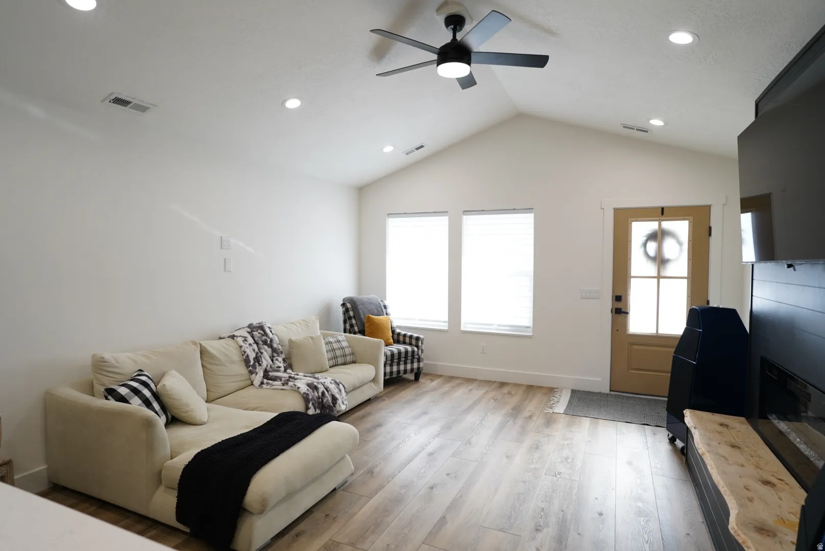 Living area featuring light wood finished floors, recessed lighting, plenty of natural light, ceiling fan, and lofted ceiling