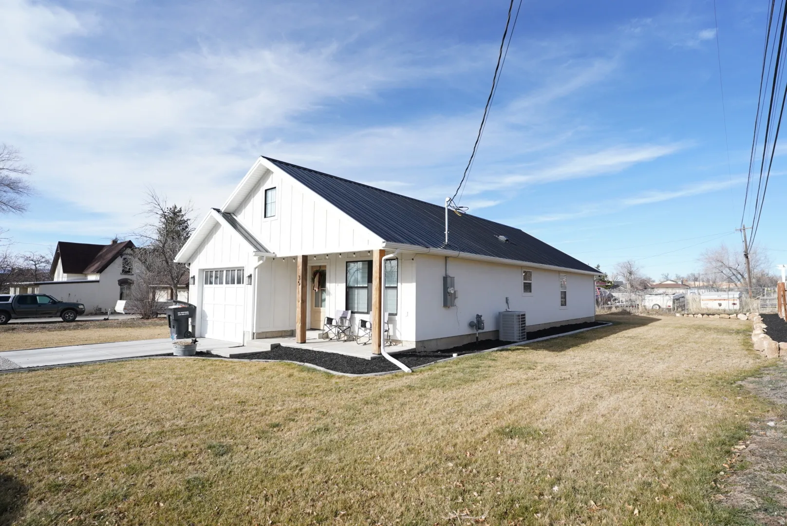 View of home's exterior featuring a porch, a yard, board and batten siding, and driveway