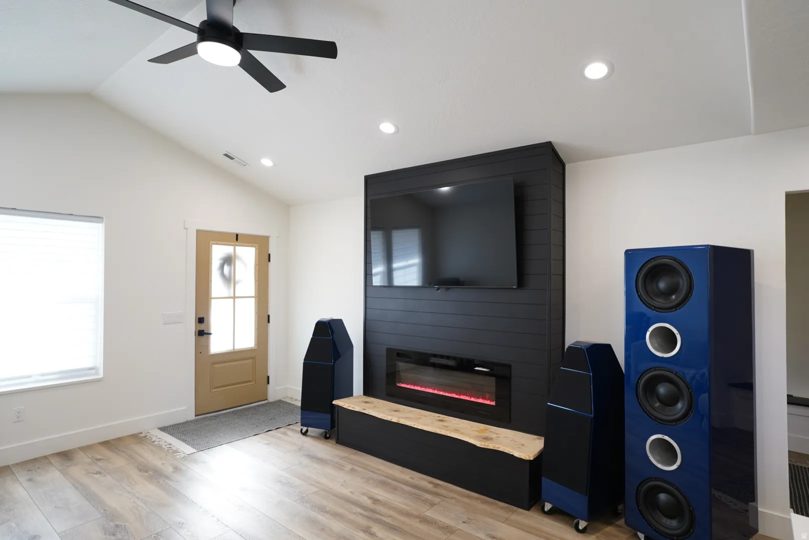 Foyer entrance with vaulted ceiling, light wood-style flooring, a fireplace, ceiling fan, and recessed lighting