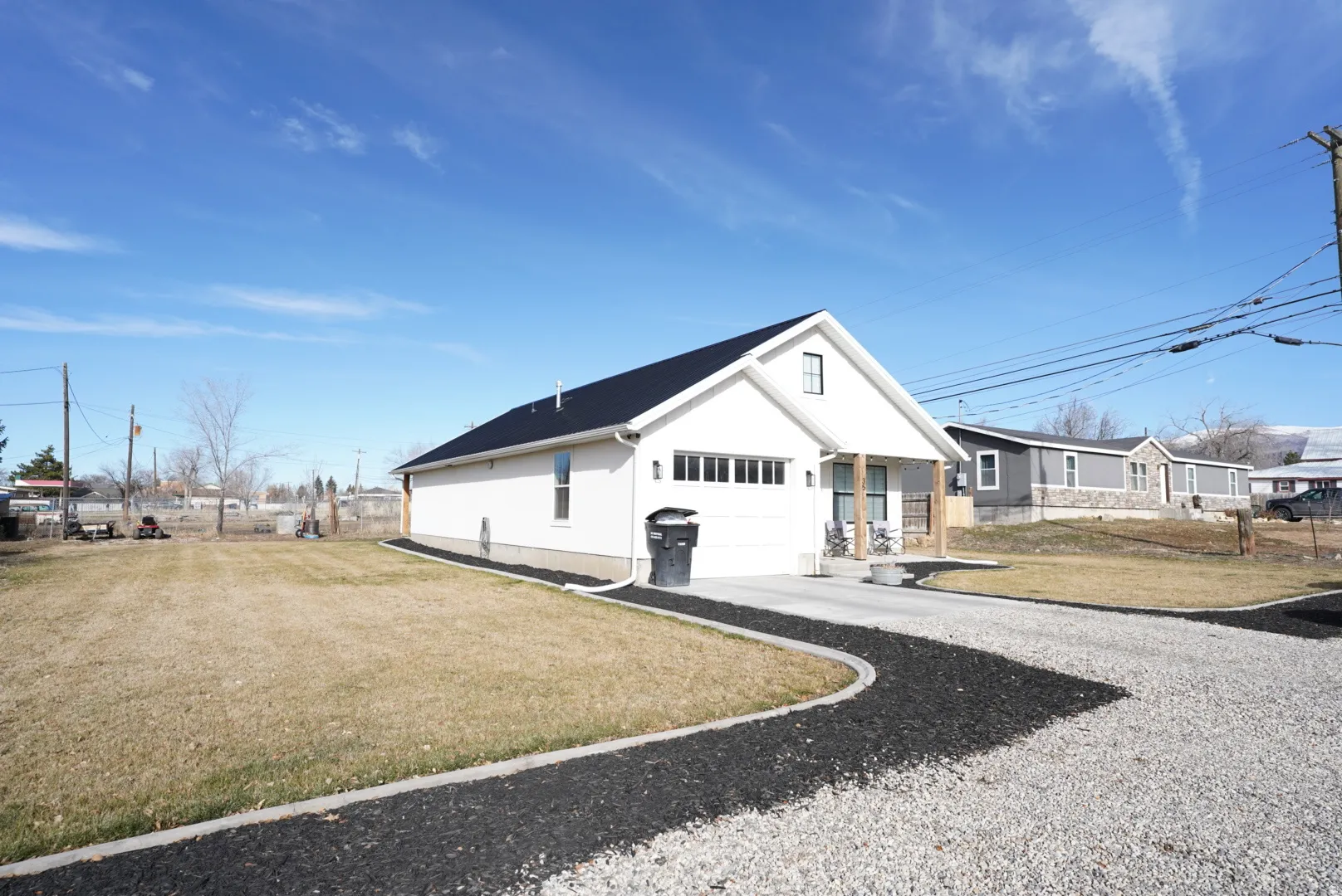 View of side of home featuring a yard, driveway, and a garage
