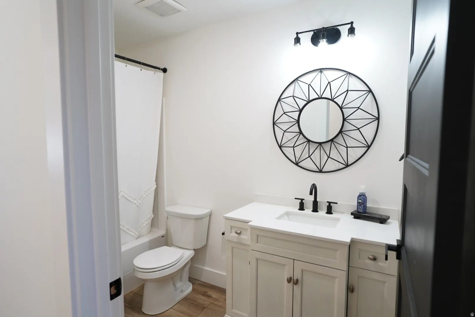 Bathroom with vanity, light wood-style floors, and shower / tub combo