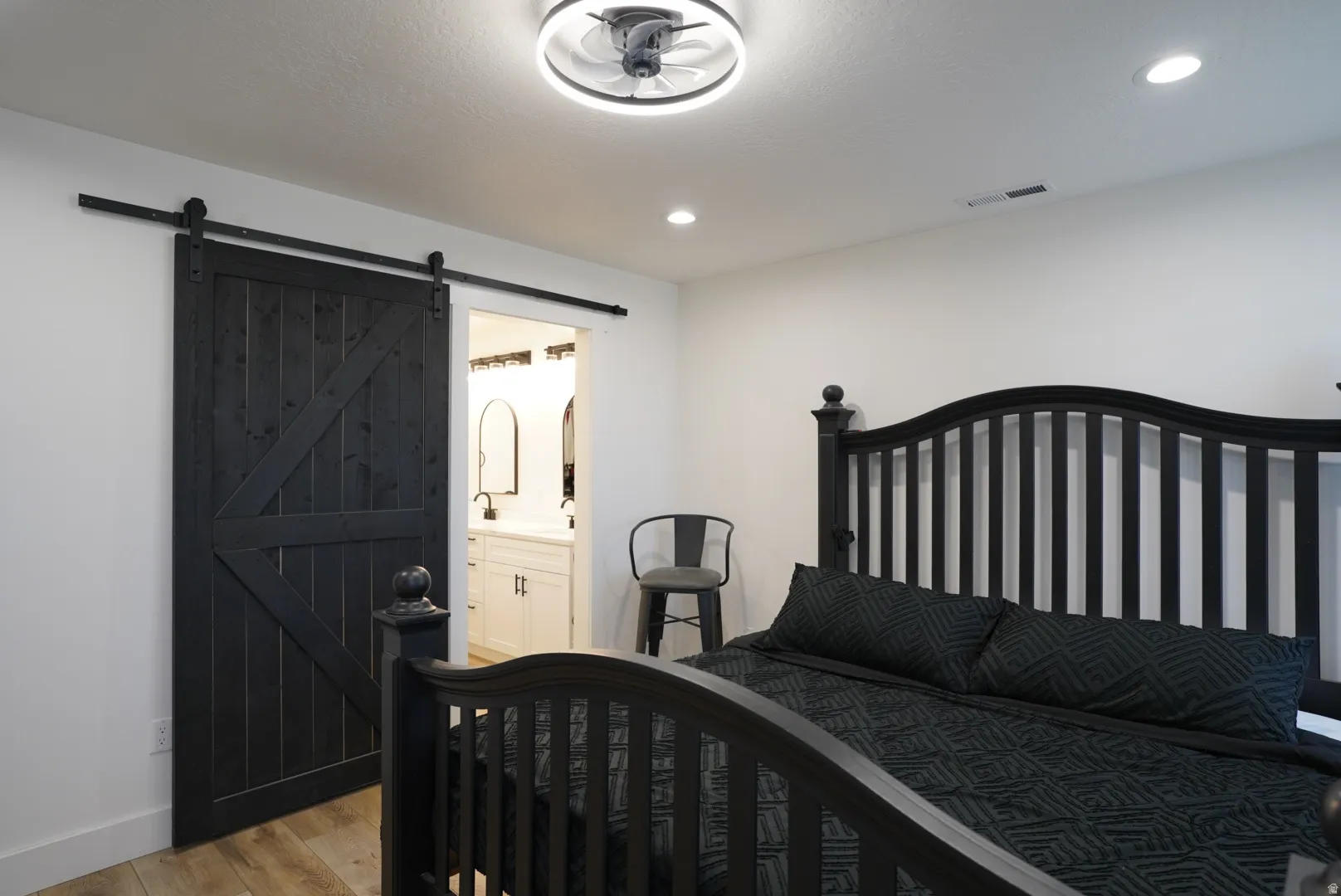 Bedroom featuring light wood-style flooring, connected bathroom, and recessed lighting