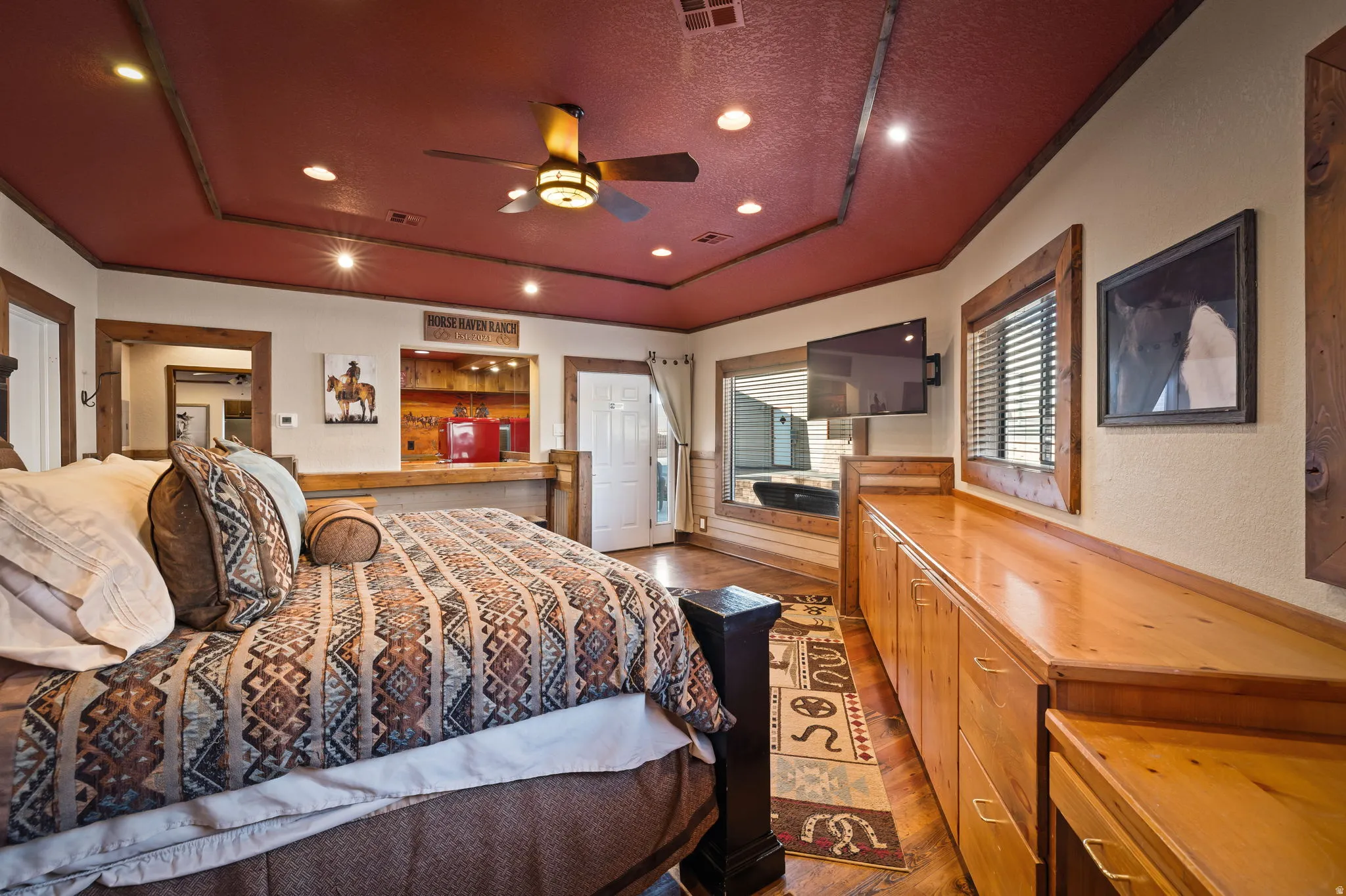 Guest Bedroom Suite with a tray ceiling, ceiling fan, a textured ceiling, recessed lighting, and dark wood finished floors