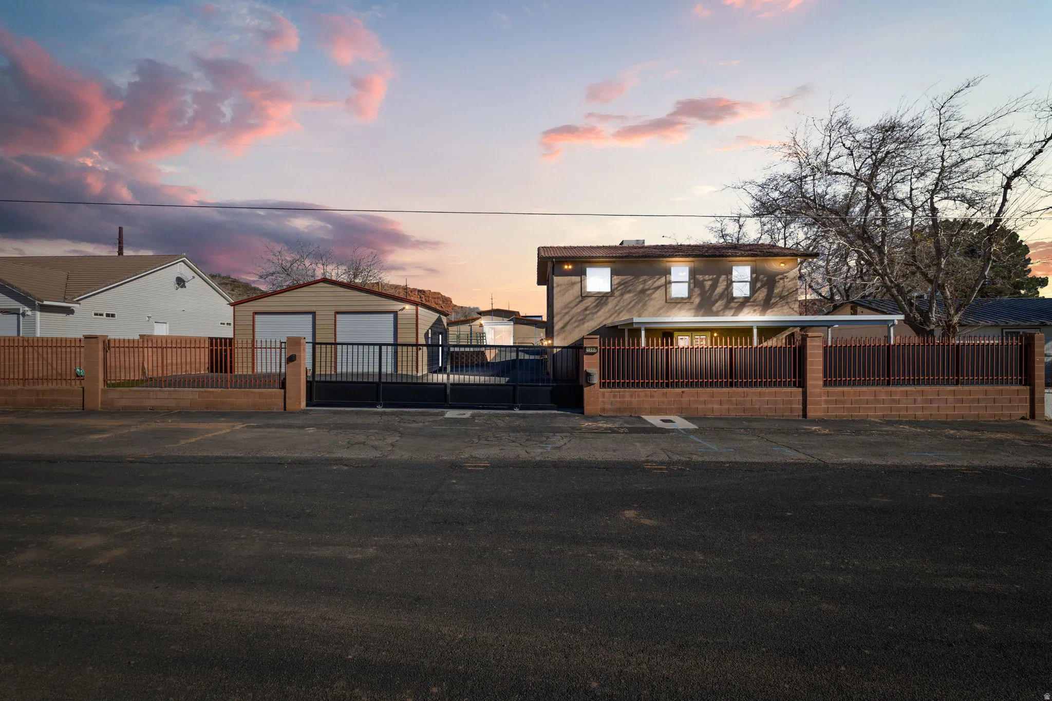 View of front of home featuring a fenced front yard, an outbuilding, and a residential view
