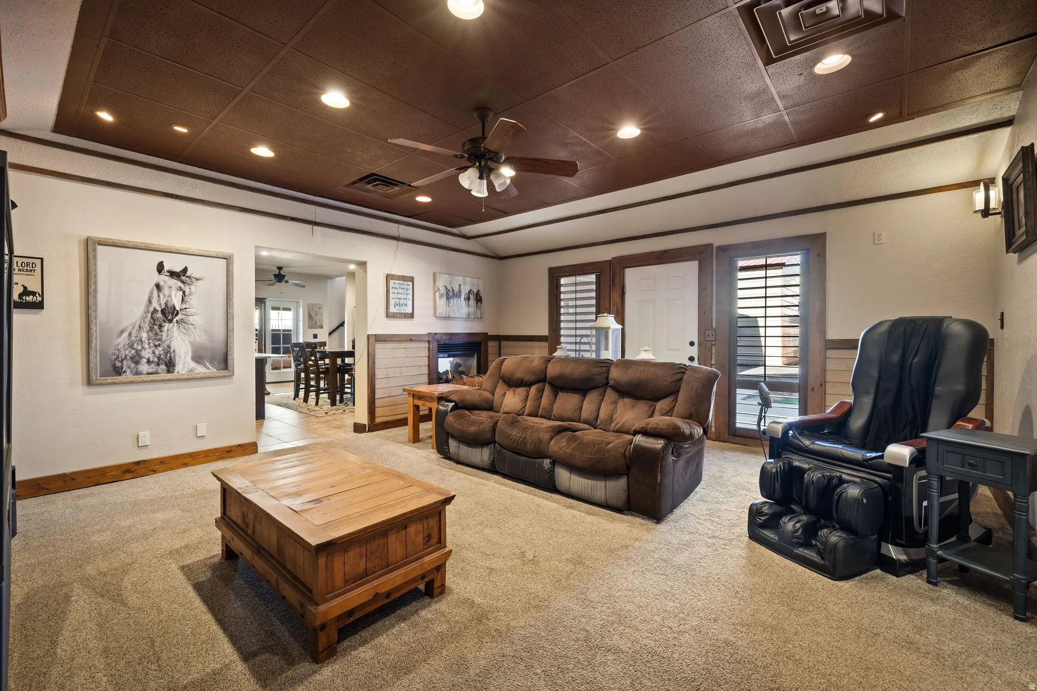 Living area featuring carpet flooring, recessed lighting, a ceiling fan, and a raised ceiling