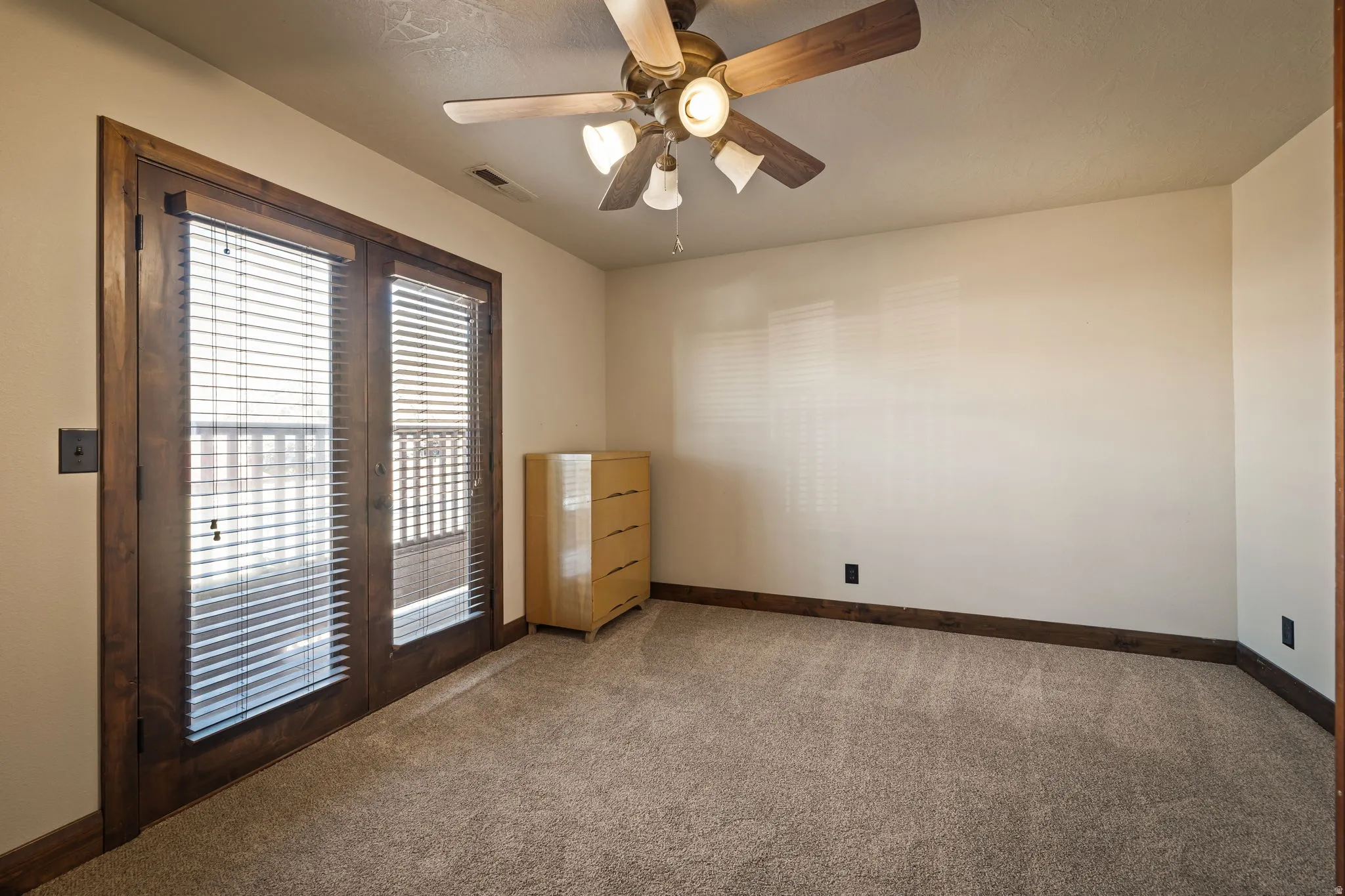 Upstairs Bedroom 1 with carpet floors, ceiling fan, and french doors