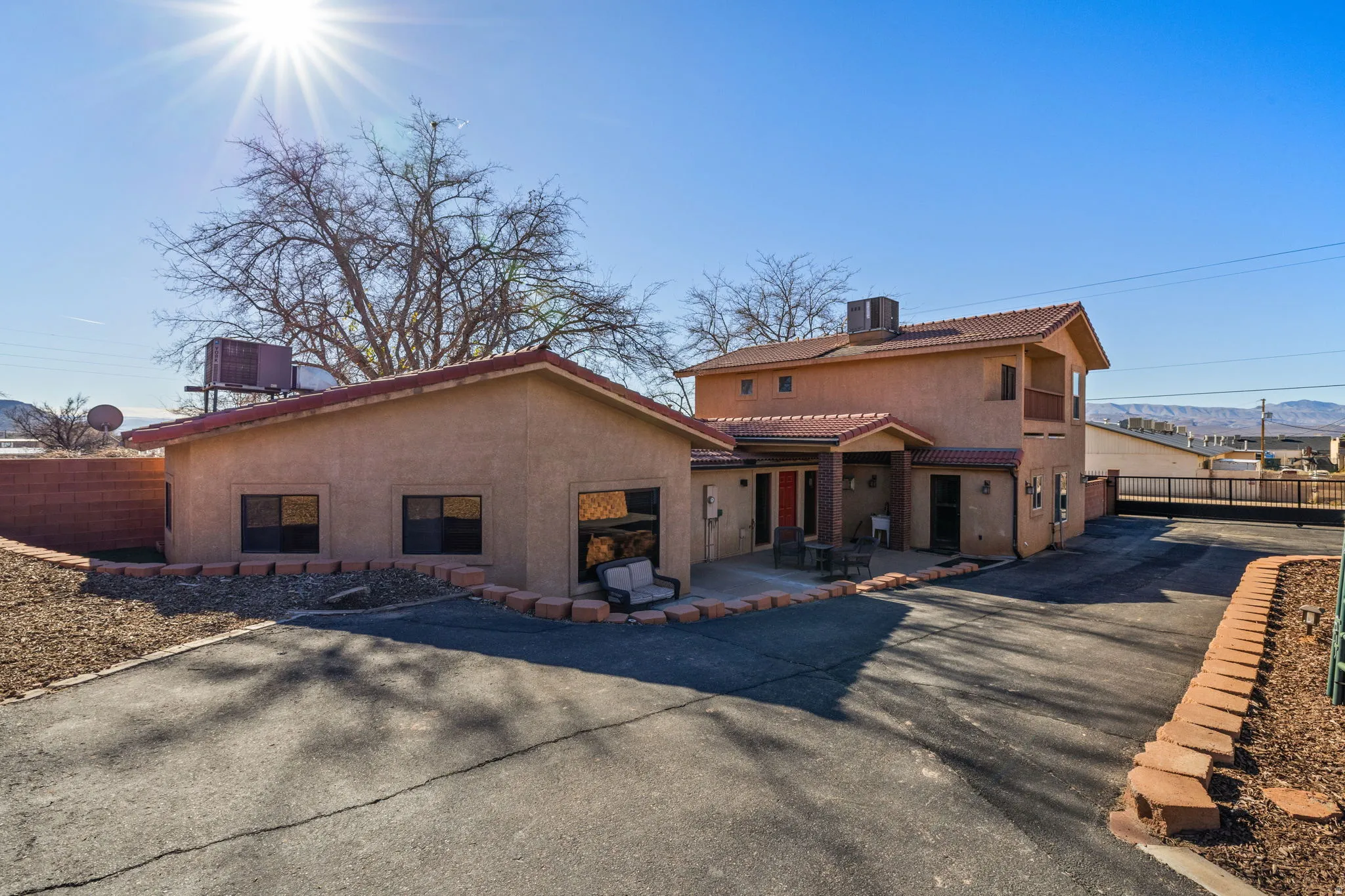 Rear view of property with stucco siding, a tiled roof, and a mountain view