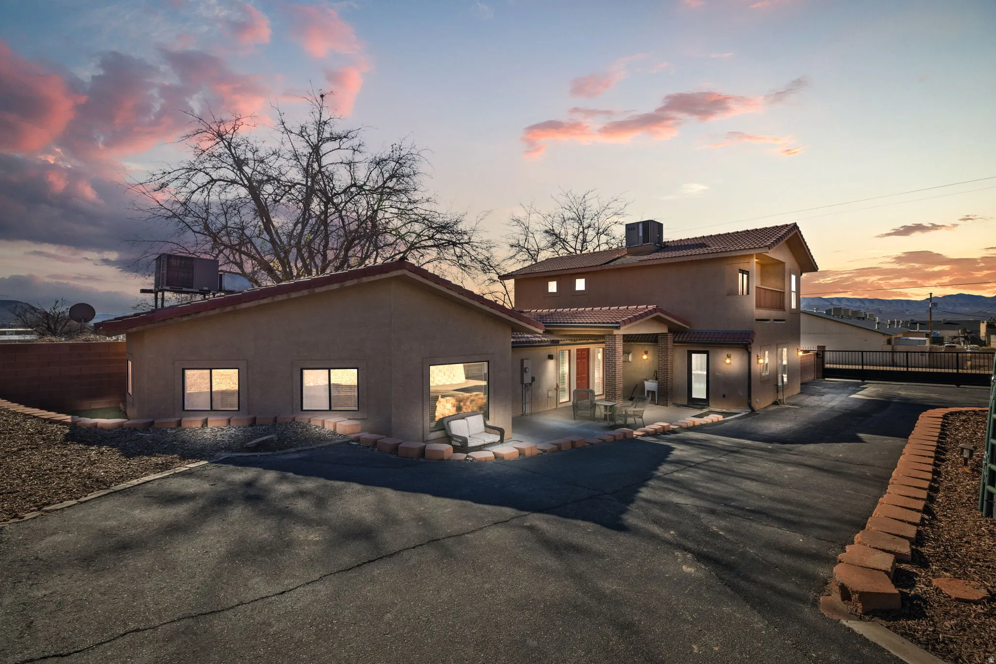 View of front facade featuring stucco siding, a tiled roof, and driveway