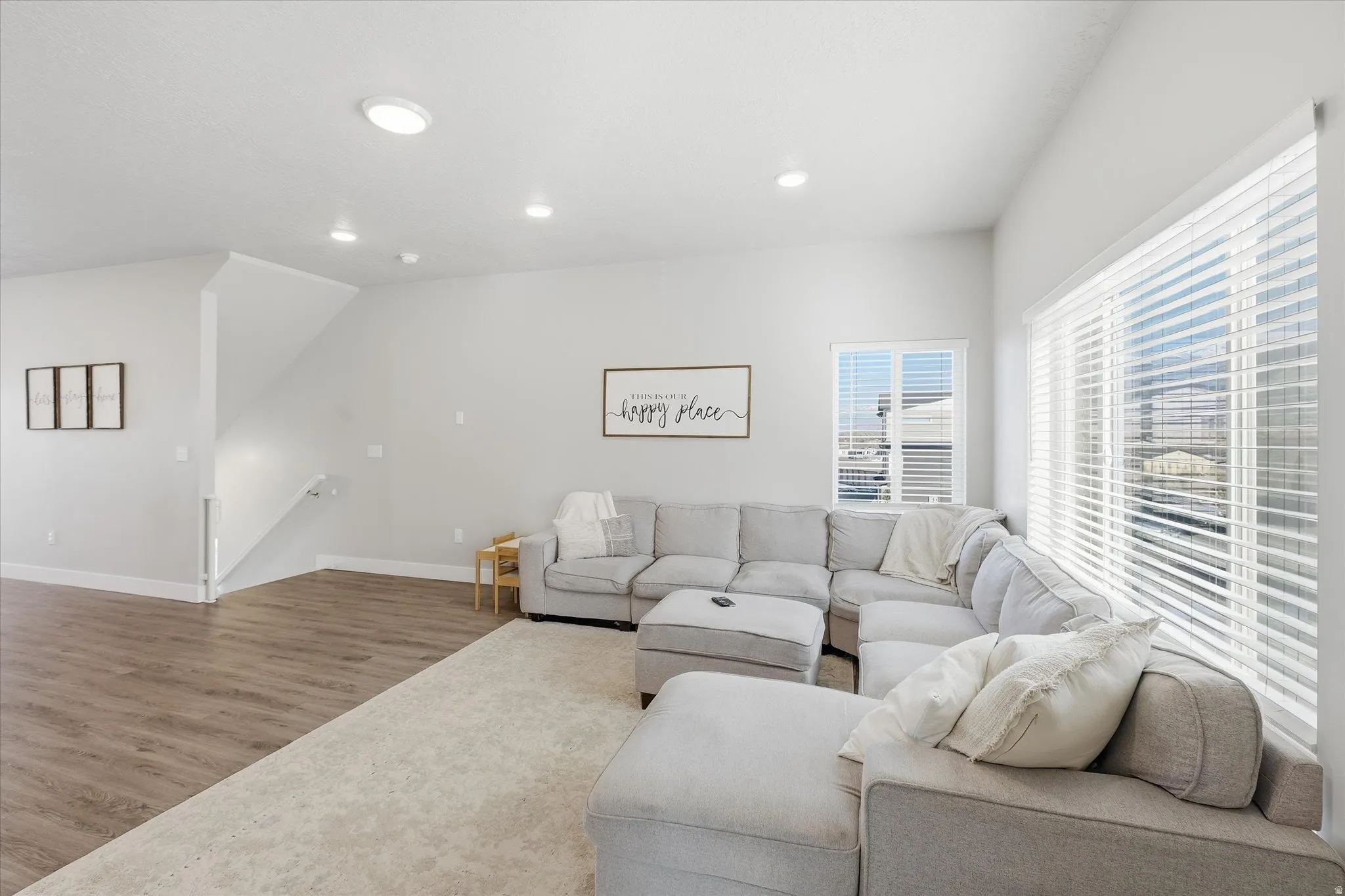Living area with wood finished floors and recessed lighting