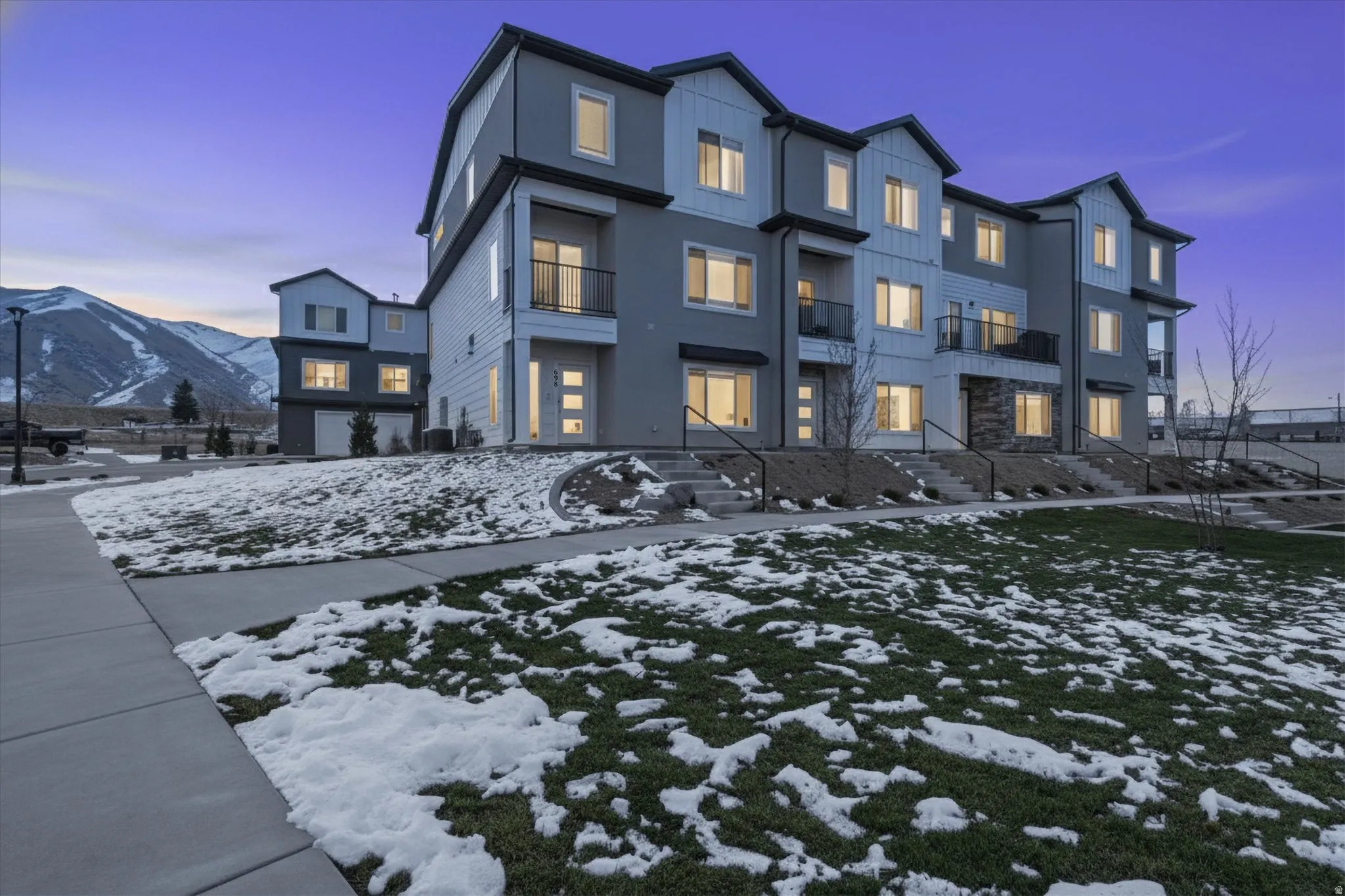 View of front of house featuring a mountain view, board and batten siding, and a balcony