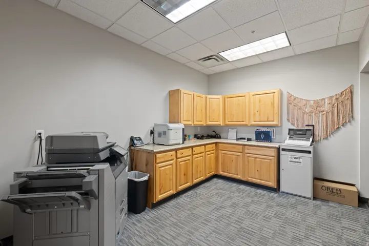 Kitchen with light countertops, light brown cabinetry, a drop ceiling, and washer / dryer