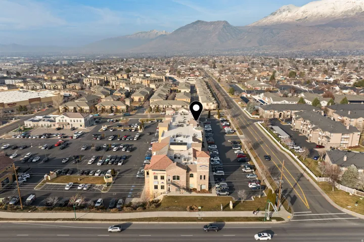 Aerial view of property and surrounding area featuring mountains and nearby suburban area