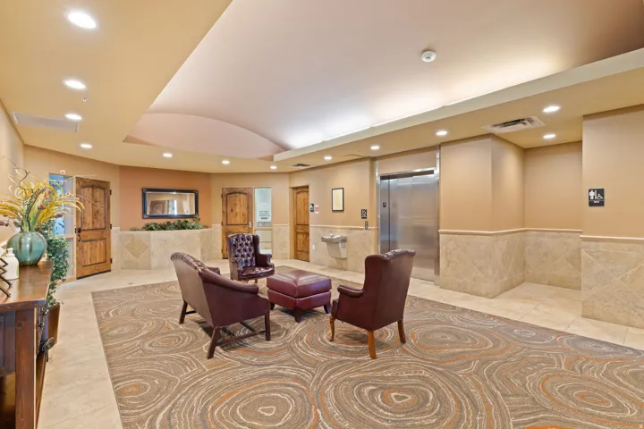 Common area featuring recessed lighting, tile walls, lofted ceiling, and a wainscoted wall