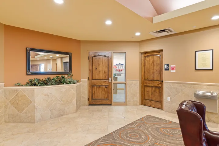 Interior space with a wainscoted wall, recessed lighting, and tile walls