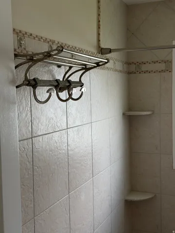 Tiled shower with decorative accent border and two built-in corner shelves