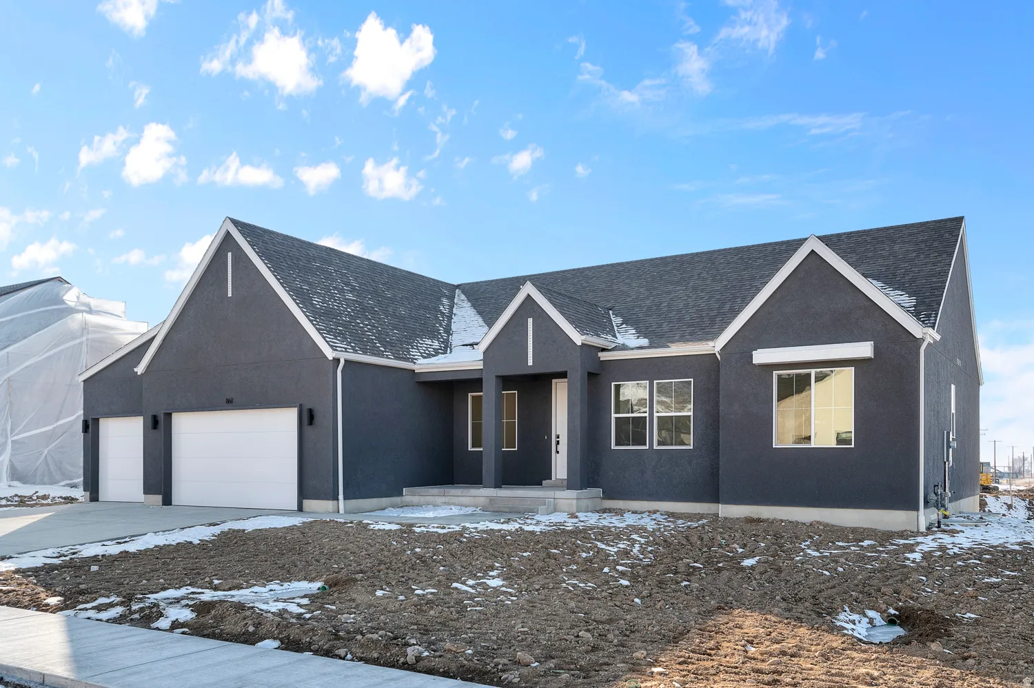View of front facade featuring stucco siding, an attached garage, and driveway