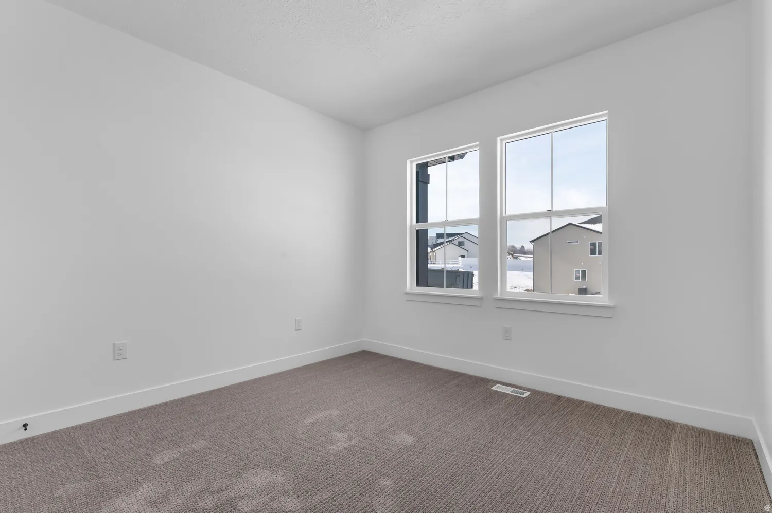 Carpeted empty room with baseboards