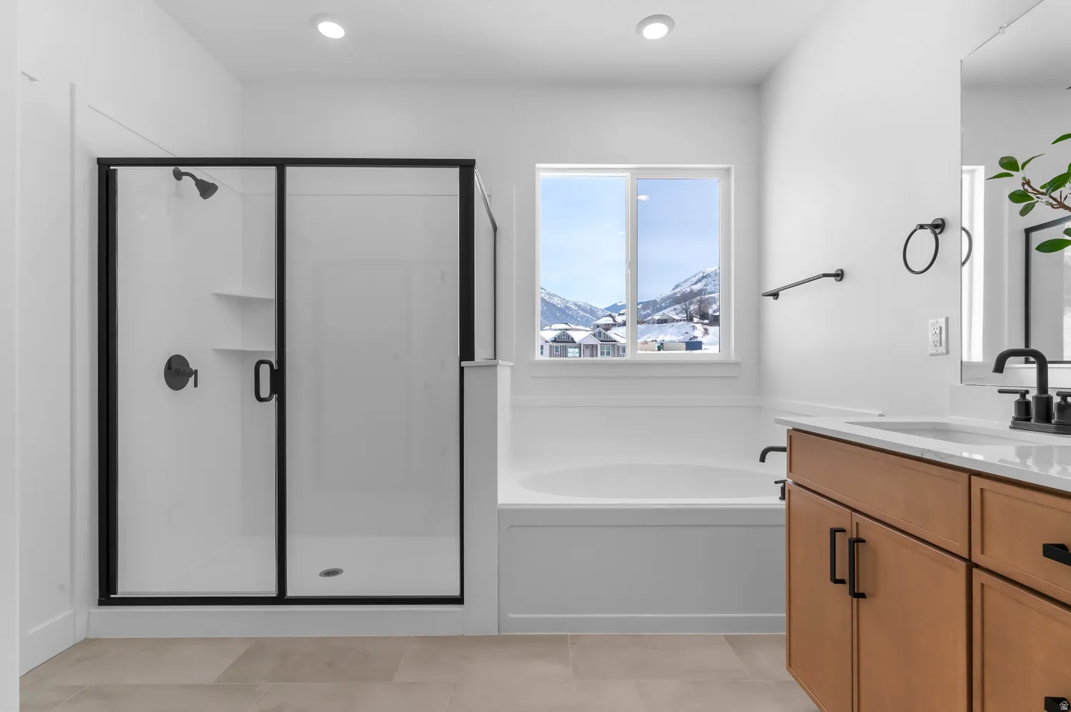 Bathroom featuring vanity, a shower stall, a mountain view, a garden tub, and recessed lighting