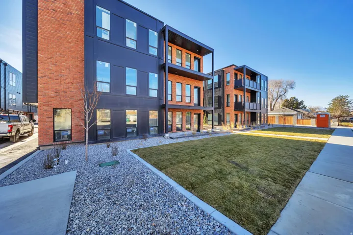 Rear view of property with a lawn and brick siding