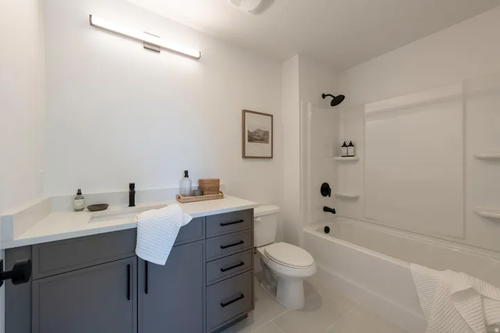 Bathroom featuring vanity, shower / bathtub combination, and light tile patterned floors