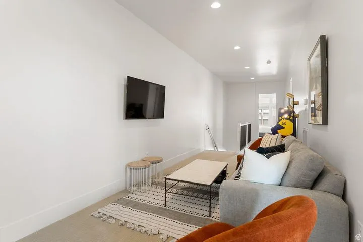 Carpeted living room featuring baseboards and recessed lighting