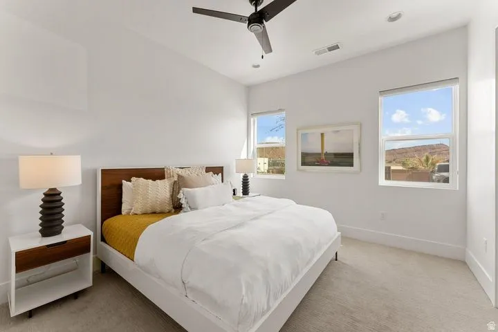 Bedroom featuring light carpet and a ceiling fan