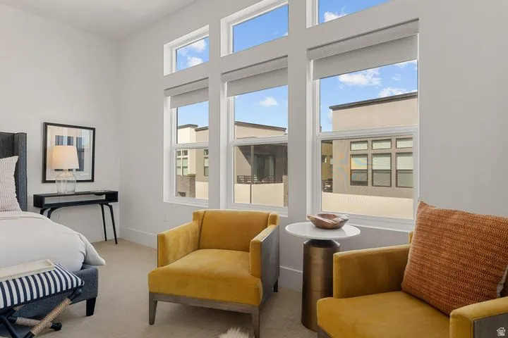 Bedroom featuring light carpet and a high ceiling