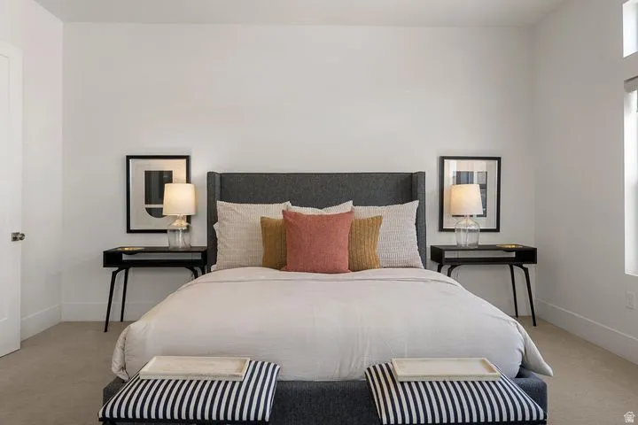 Bedroom featuring light carpet and multiple windows