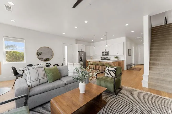 Living area with light wood finished floors, recessed lighting, stairs, and a ceiling fan