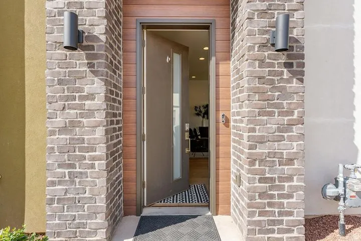 Doorway to property featuring brick siding