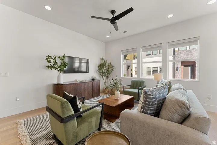Living area with light wood finished floors, recessed lighting, and ceiling fan