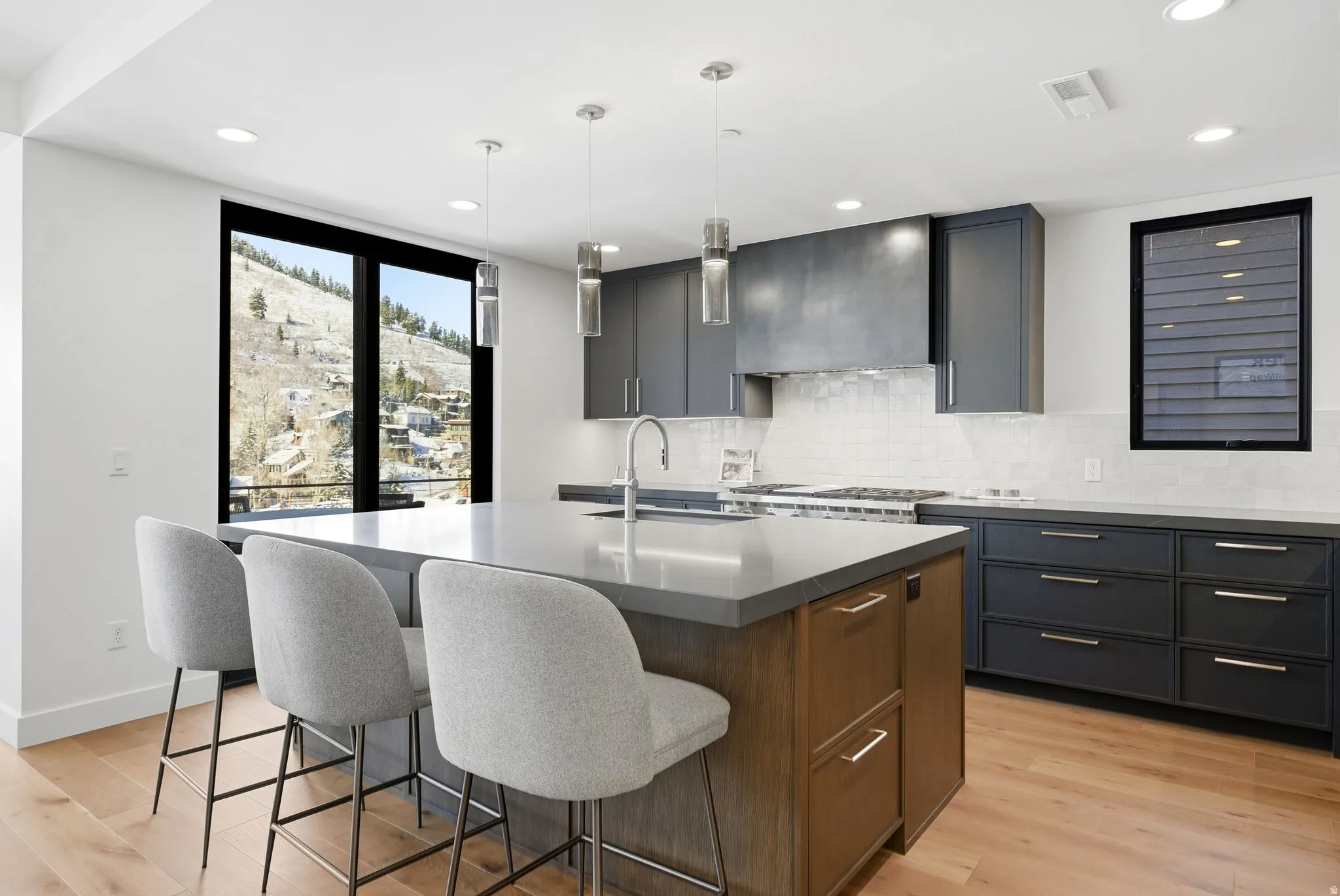 Kitchen with pendant lighting, light wood-type flooring, a center island with sink, a breakfast bar, and recessed lighting