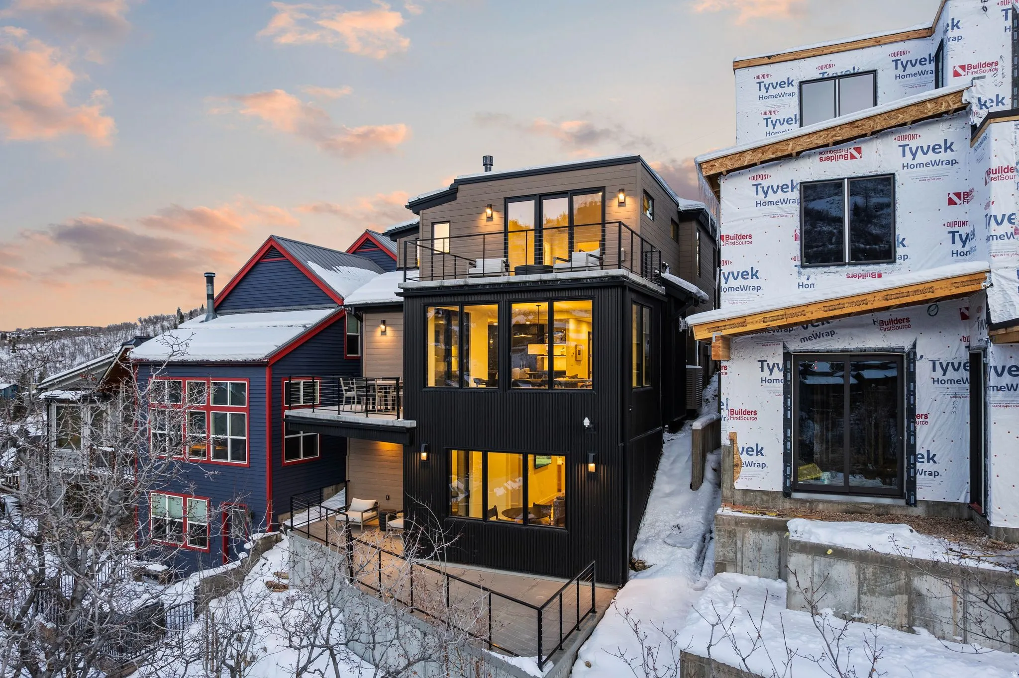 Snow covered back of property with a balcony