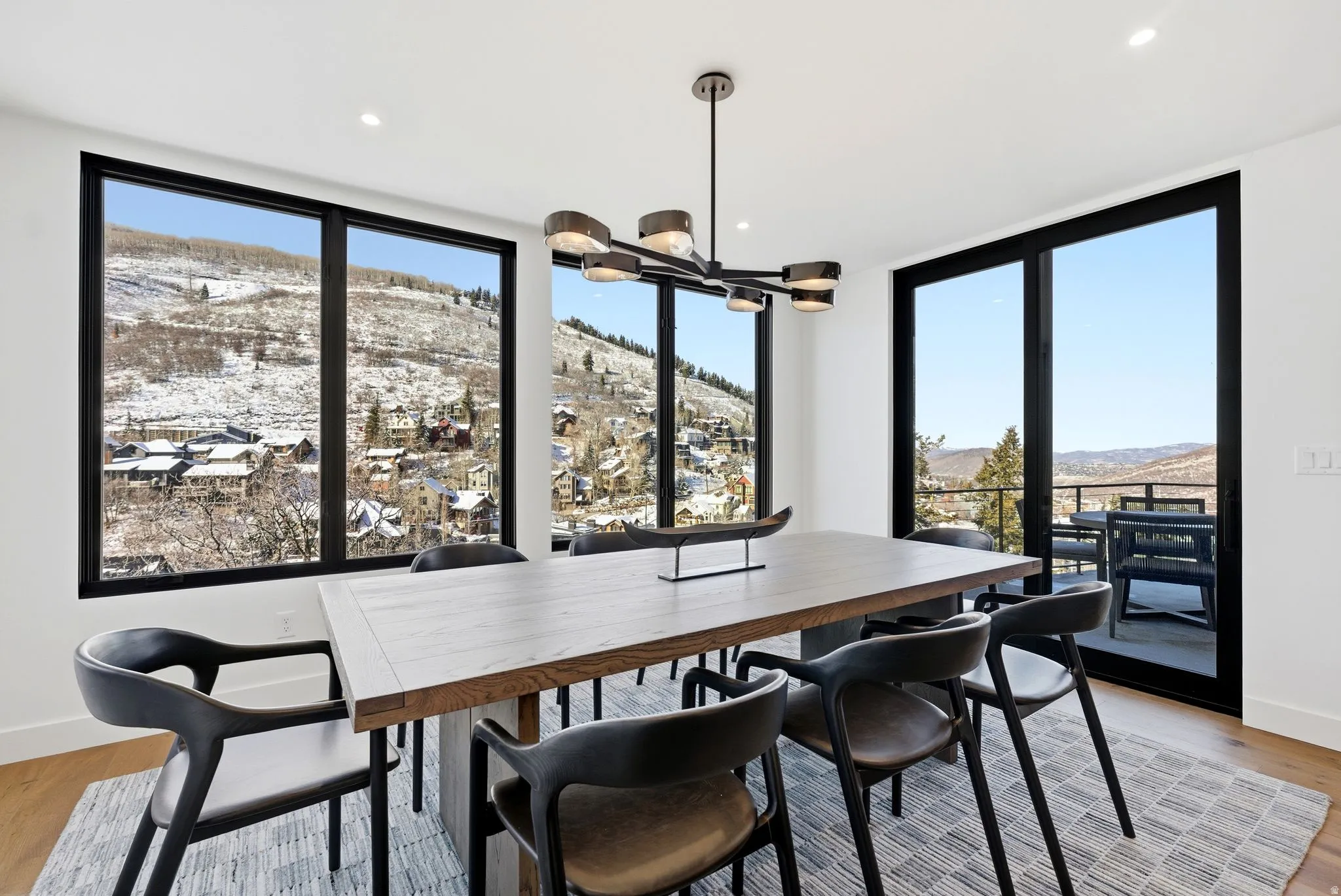 Dining space featuring light wood-style floors, a mountain view, a chandelier, recessed lighting, and a wall of windows