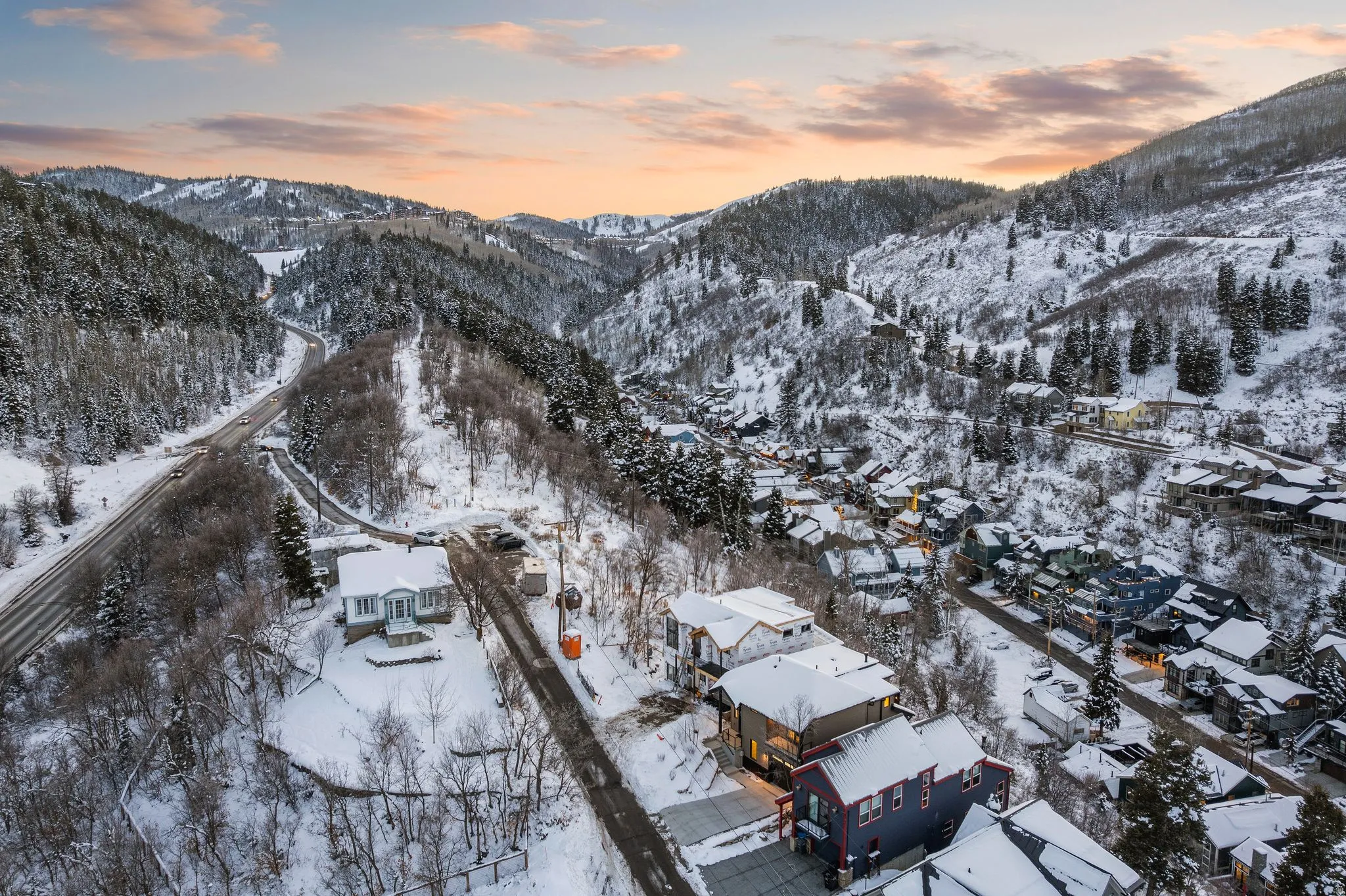 Snowy aerial view featuring a mountain view and a residential view