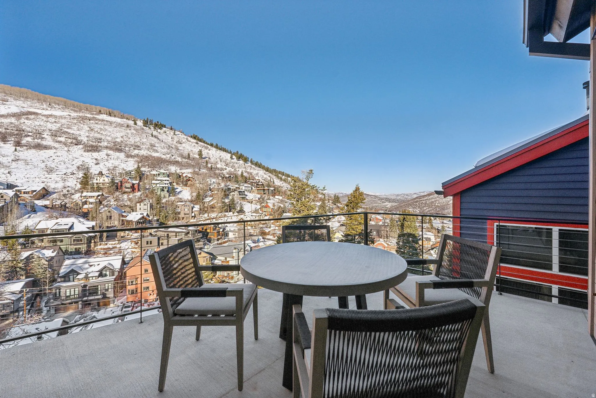 Snow covered back of property featuring a mountain view and a patio