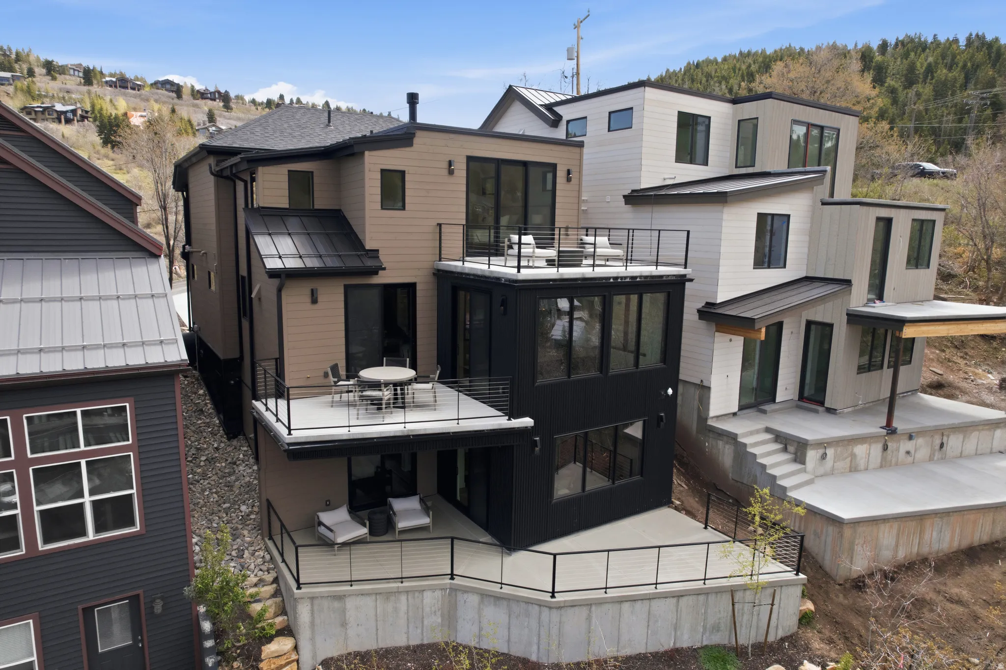Contemporary multi-level residence featuring a combination of tan horizontal siding and black vertical siding