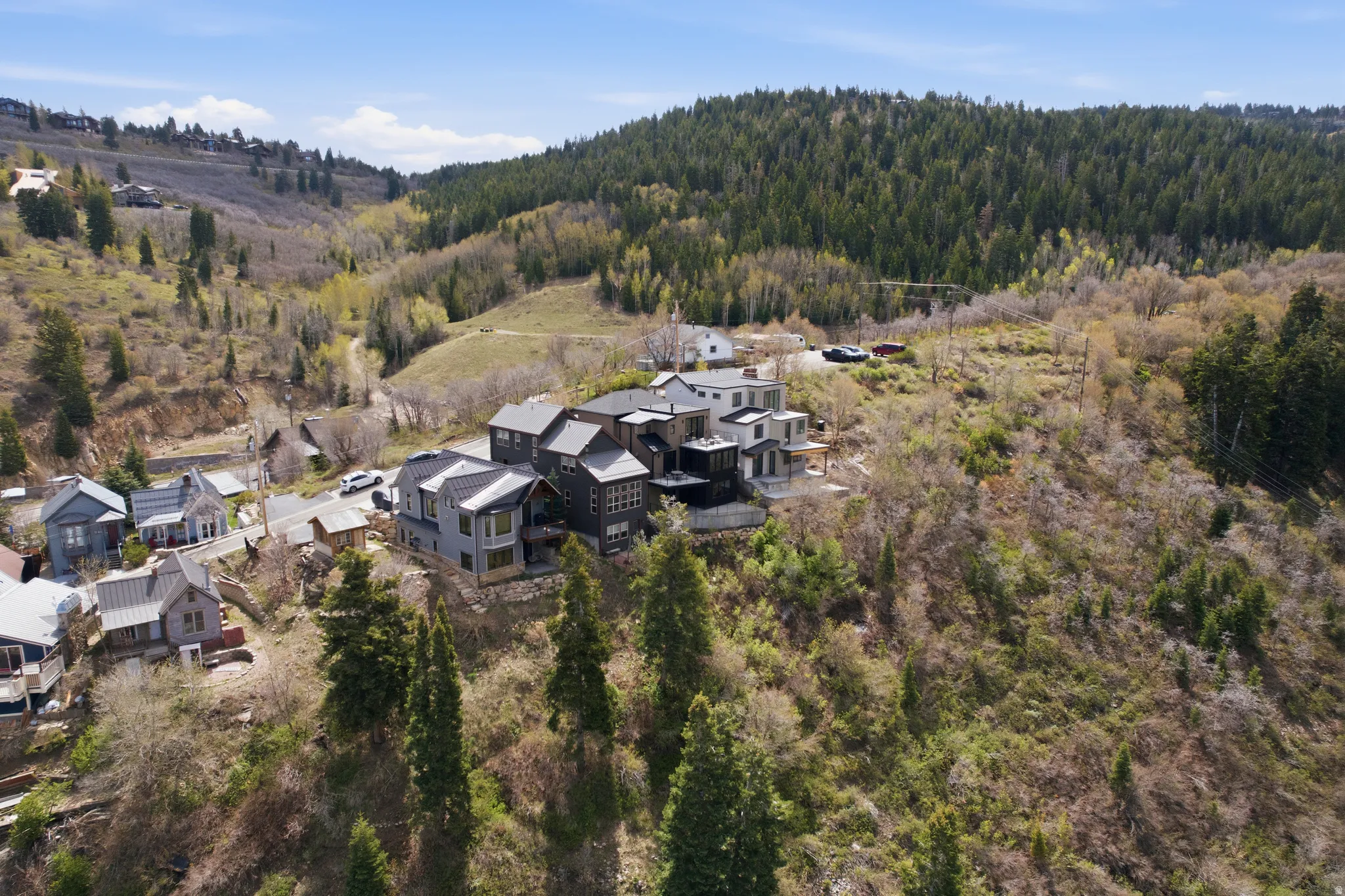 Hillside property featuring multiple residences with modern architectural designs and various rooflines