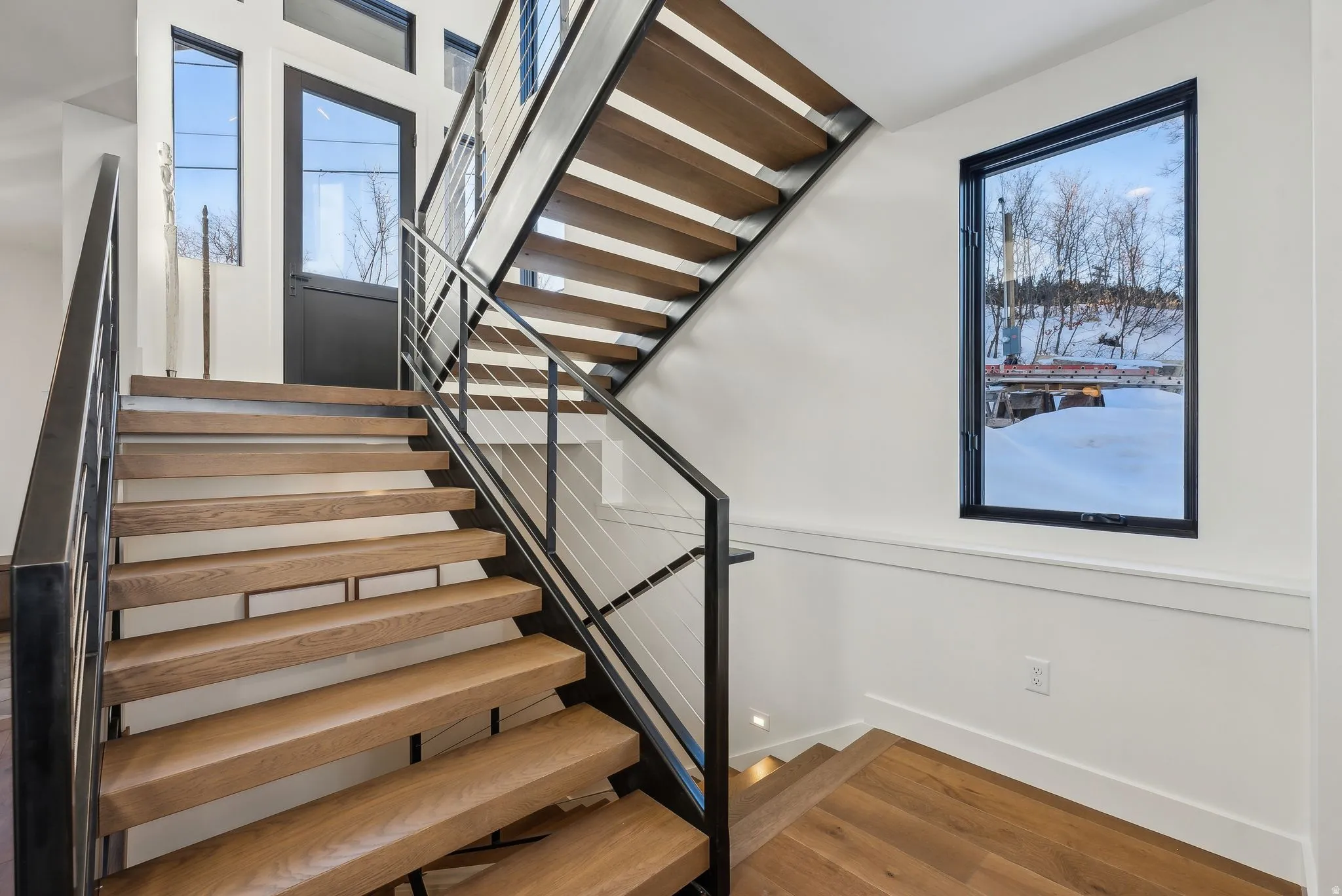 Staircase featuring wood finished floors and baseboards