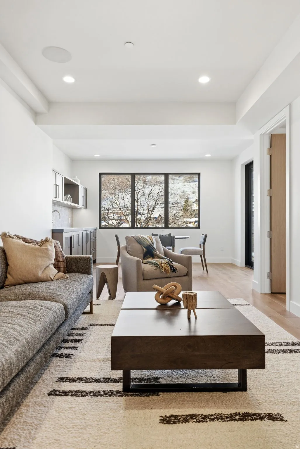 Living area with light wood-type flooring and recessed lighting
