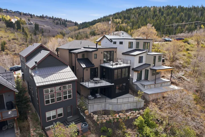 Modern multi-level residence with distinct architectural styling, multiple outdoor patios, and a contemporary metal roof