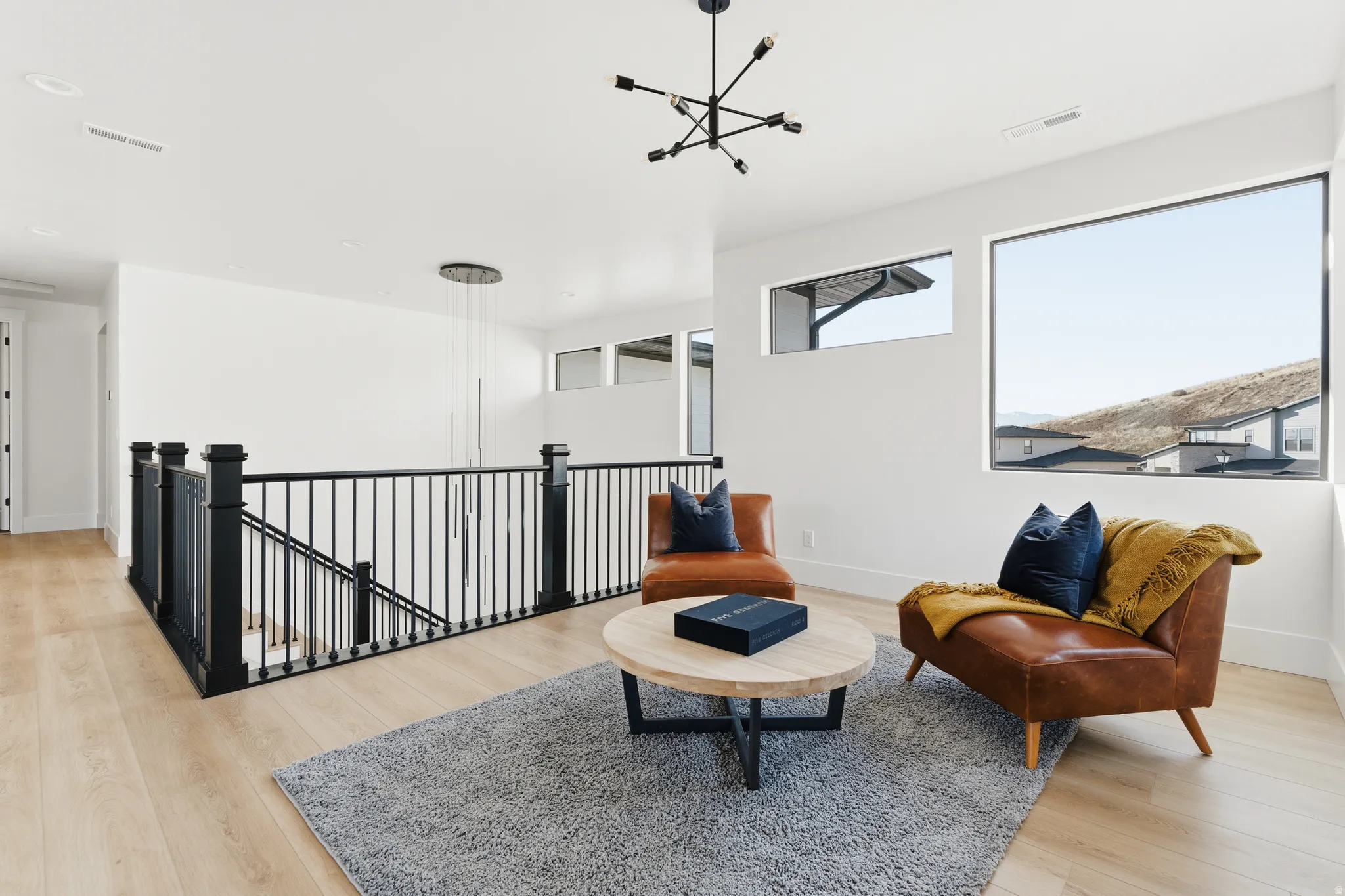 Sitting room featuring an upstairs landing, light wood-style flooring, and a chandelier