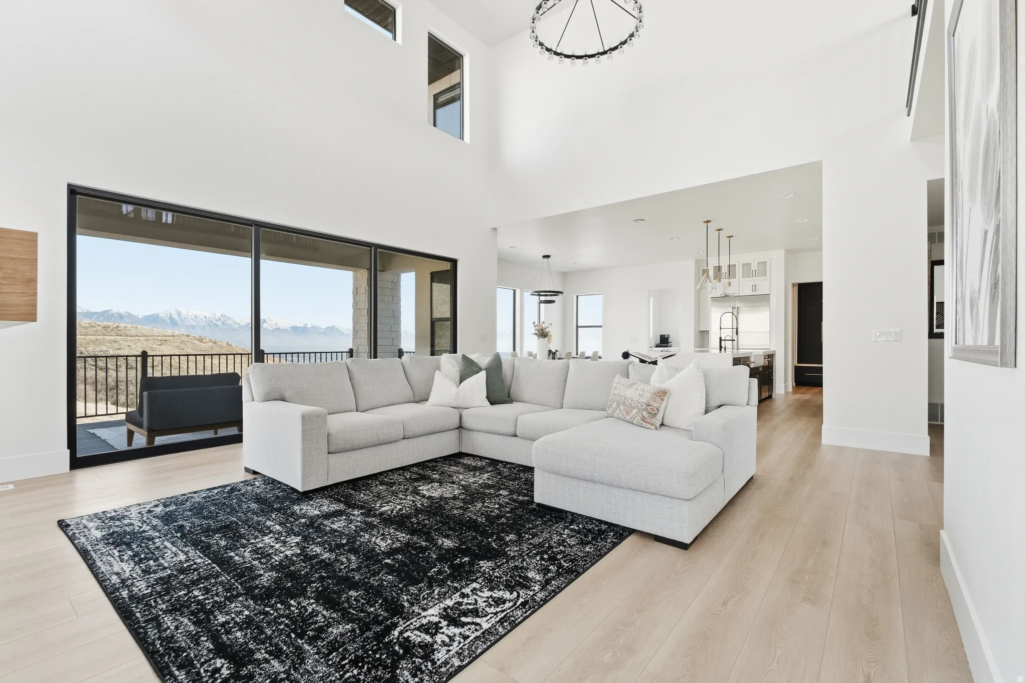 Living room with light wood finished floors, a mountain view, and a high ceiling